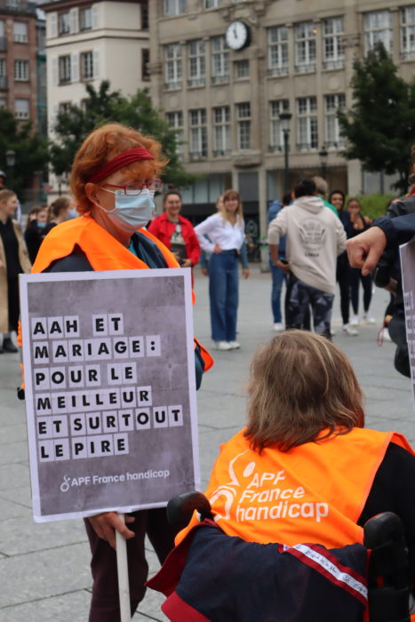Photo d'un manifestant portant le message "AAH et mariage : pour le meilleur et surtout le pire” AFP France handicap